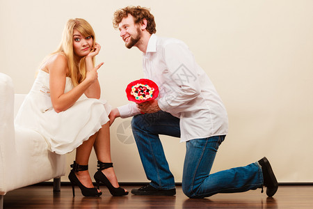 英俊男人在女朋友面前跪下献给不开心女人的糖果图片