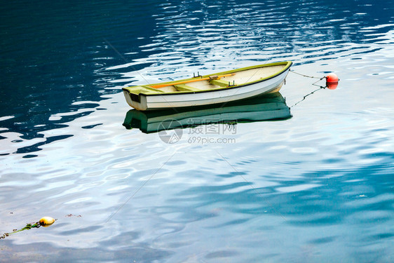 在蓝水海或湖面的小型固定船只图片