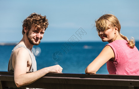 遇见恋人一对夫妇在海边约会露天年轻女孩和男人坐在长凳上夏天的爱夫妇和女人在户外约会背景