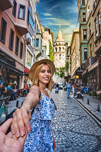 身着时装的美丽年轻旅游女孩握着一对夫妇的手图片
