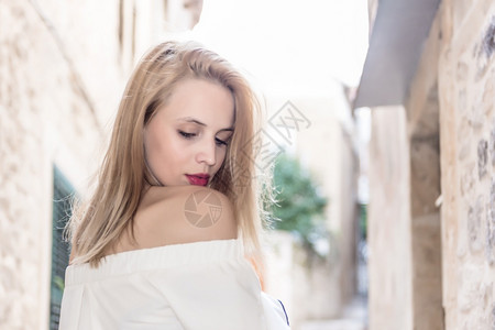 纪梵希口红穿着时装白色上衣的有吸引力年轻女穿着时装白色上衣的有吸引力女背景