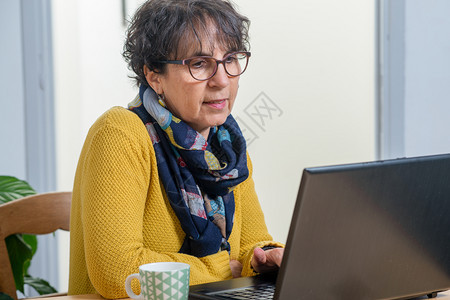 一位美丽的黑发女肖像家里有笔记本电脑的成年女子图片