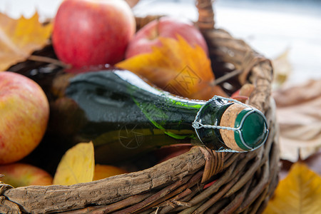 一篮子有瓶苹果和美味的秋叶背景图片