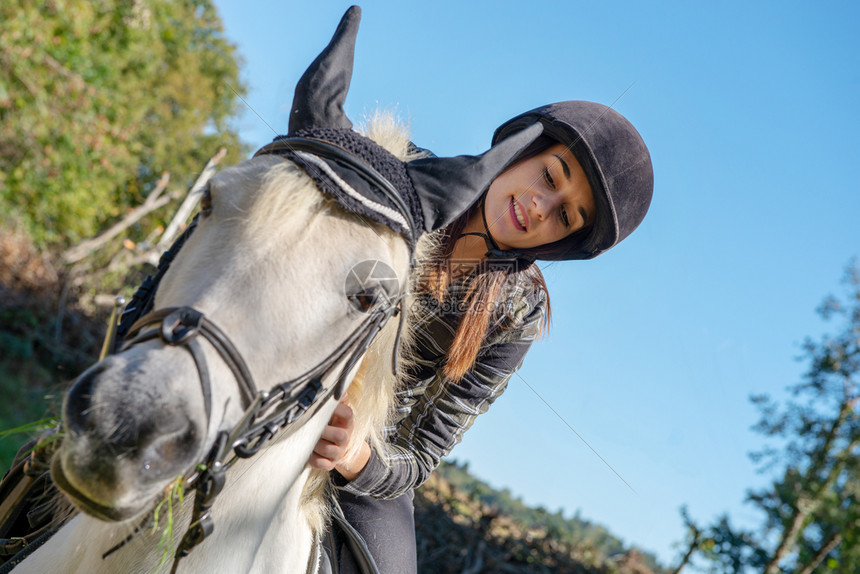 一位骑着白马的年轻女人肖像图片
