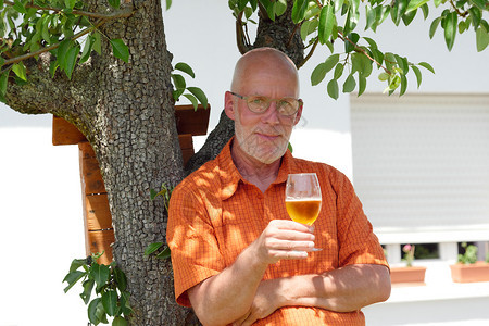 一个成熟男人在外面喝啤酒背景图片
