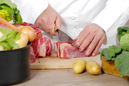 大厨在木板上切肉图片