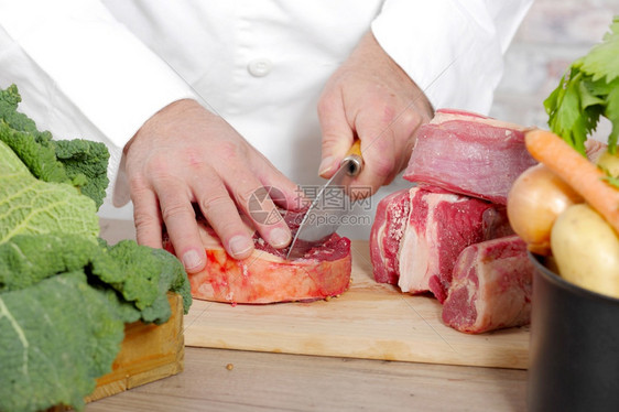 大厨在木板上切肉图片