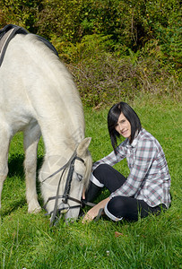 白马骑着的漂亮年轻黑发美女图片