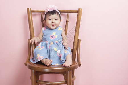 可爱的亚洲女婴是粉红背景的肖像图片