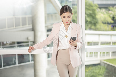 美丽的女商人正在使用智能电话做生意图片