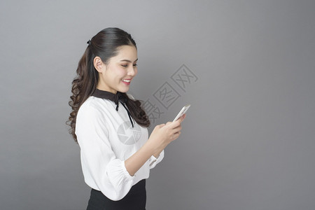 美丽的商业女肖像正在工作室使用手机高清图片
