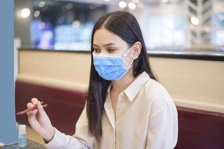 由于科罗纳大流行女在餐厅吃着社会迷魂药而新冠大流行图片