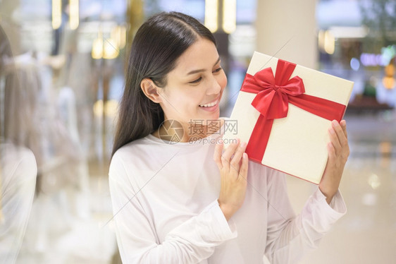 在购物中心感恩节和圣诞概念中持有礼品盒的妇女图片