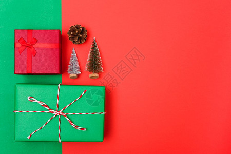 新年圣诞节的构成带有礼品盒的顶端观景绳子的割缝红绿树枝和色背景的树枝以及复制空间图片