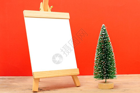 圣诞成像装饰最小绿色fir树枝红底有雪和白黑纸板圣诞快乐概念文本复制空间图片