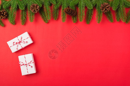 红色喜庆中国风背景新年或圣诞节快乐最上方的视野平铺放fir树枝和礼品盒装饰红色背景并装饰您文本的复制空间背景