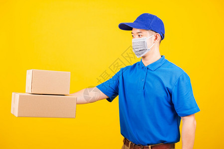 身穿蓝色T恤衫和制服的亚洲年轻送货工人身穿蓝色T恤衫和帽子制服的亚洲青年工人侧边背景图片