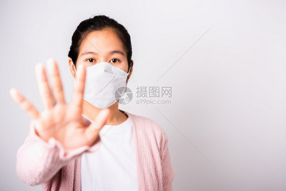 身穿外科保护的亚洲妇女面对冠状的罩卫生她举起手停牌图片