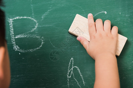 后亚洲可爱小男孩幼稚儿园校服擦干净或黑粉绿色学校板上用海绵擦粉第一次到学校教育概念图片