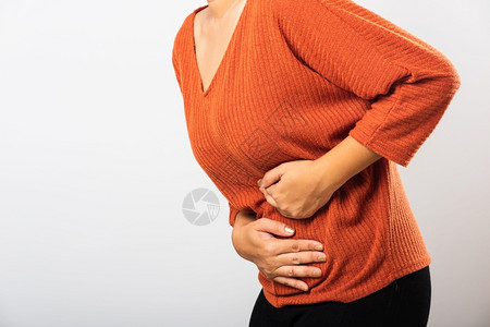 提高一分她生病的亚裔妇女有胃痛肚子手握在腹部身体的一分女有痛苦的胃腹部发炎或慢胃工作室被孤立在白色背景上背景