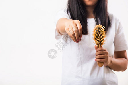 亚洲妇女不快乐的柔弱头发问题她拿着梳子中长发被损坏的她从刷子上拉掉的头发孤立在白色背景上医学保健概念图片