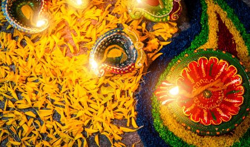紧的粘土点燃了已经对Diya或油灯的火焰鲜花放在混凝土背景上印度兰焦利教的装饰迪瓦利印度节庆祝活动快乐或迪瓦利印度节的概念背景图片