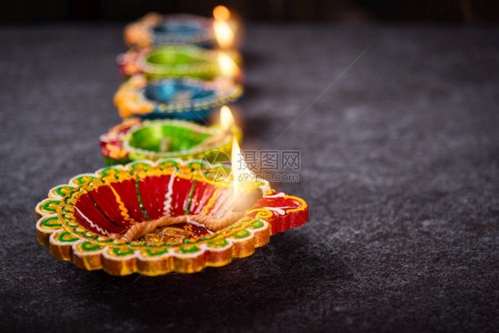 Diya或油灯已经燃起火光摄影棚在混凝土背景上拍摄印度兰焦利的装饰庆祝快乐迪帕瓦利或节的概念图片