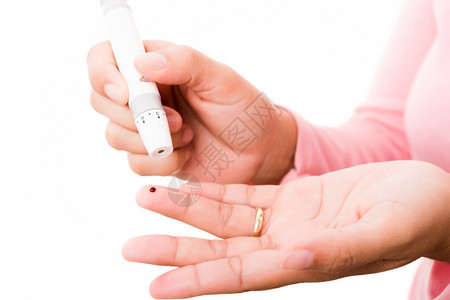 测量葡萄糖试水平用血压计检查手指的妇女背景图片