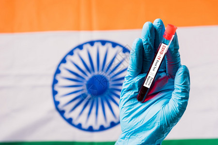 在印度旗下实验室内戴手套并持有验血管冠状COVID19COVID19的医生手印度疫苗接种背景图片