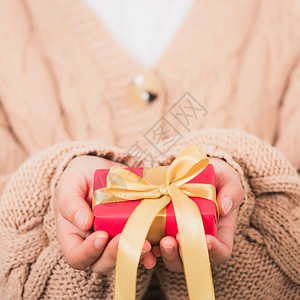 情人节女美手拿着小礼物盒随身带丝的包裹纸白色背景生日新年圣诞节日背景概念图片