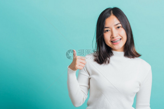 年轻美丽的亚洲女士欢笑的着举起手指拇肖像快乐的女图片
