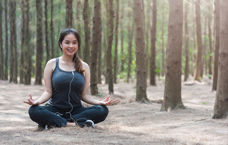 年轻妇女的生活方式在森林自然面放松在上午静坐默瑜伽图片