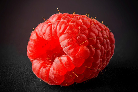 黑色背景的新鲜草莓切口红新鲜的红莓切口图片