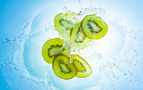 Kiwi水果切片在浅蓝色背景的孤立下冲入清水中健康食品概念Kiwi水果切片冲入清中图片