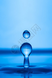 水滴落到蓝表面健康和纯洁的概念水滴涌到蓝表面图片