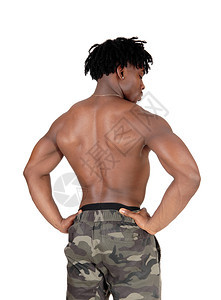 一个年轻英俊的健美运动员站在后背的穿着迷彩短裤向下看与白背景隔绝图片