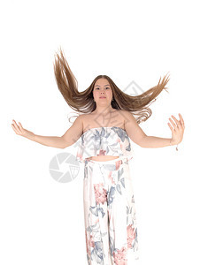 一个穿着面纱的年轻少女穿着面纱的衣跳上下头发飞起来手臂被切开白种背景隔离背景图片