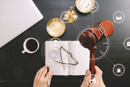 正义和法律概念男法官手拿木槌铜秤和电脑在法庭上的俯视图打开深色木桌上的圣经书用Vr图背景图片