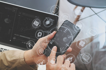 使用智能电话和数字平板脑在现代办公室使用虚拟计算机界面图形和标进行在线银支付通信图片