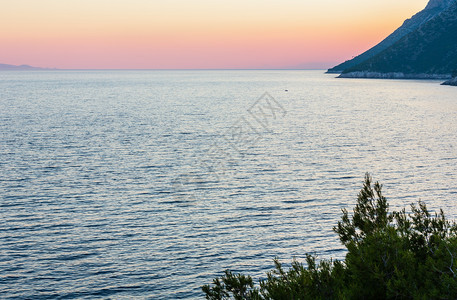 夏季傍晚的海岸线粉色日落和闪亮的水面斯通佩列萨克半岛罗地亚图片