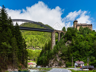 奥地利提罗尔州兰戴克巴斯南谷Wiesberg城堡前的特里桑纳河和Silvretta公路上的夏季阿尔卑斯山Trisanna铁路桥图片