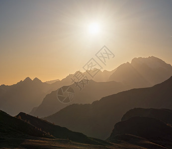 夜晚的昏暗天空和山丘环影中太阳发光从GiauPass和平地看气候环境和旅行概念场景图片