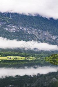 奥地利Hallstattersee的雨和云早上在奥地利风景喷雾湖森林田地牧场草和村庄图片