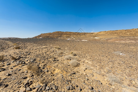 以色列内盖夫沙漠的落基山以色列南部岩层令人窒息的景象被瓦迪斯山和深坑打断的尘土山背景图片