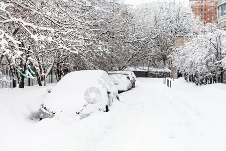 在莫斯科市住宅区横渡冬季日在莫斯科市住宅区沿公路停车的上放雪覆盖汽车图片