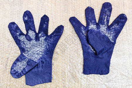 使用湿感觉工艺蓝色梅里诺羊毛用手套制带有形手指和切割图案的湿手套图片