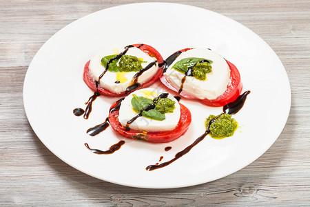 意大利菜烹饪Insalatacapresecapresesalase切片莫扎里拉奶酪番茄含橄榄油的basil叶子白醋和木制桌上板图片