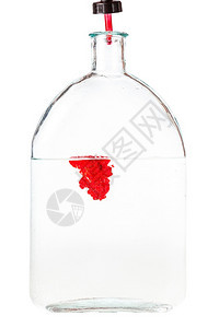 在白色背景隔离的玻璃瓶中滴在水的红墨滴在白色背景的玻璃瓶中滴在水的红墨滴在背景图片