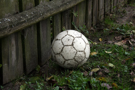 足球是一座旧木墙附近的草地上球老场栅栏图片
