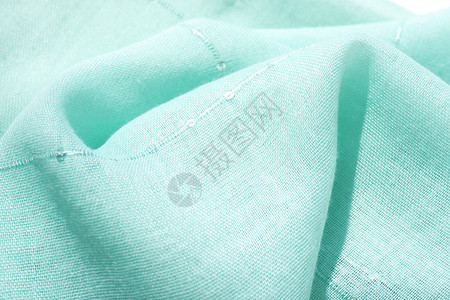 明亮的蓝色背景和毛质棉织布有薄荷色带小亮片用折叠制成织物图片